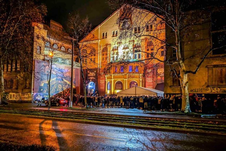 Farbig beleuchtete Fassade des historischen Stadtbads Leipzig am Abend